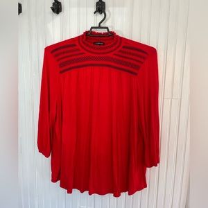 High neck blouse. Red with black embellishment.